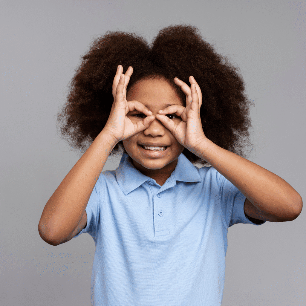 Portrait of little cute girl making circle with her hand on her eyes